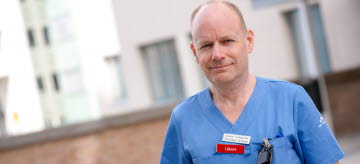 Johan Liliequist står i blåa sjukvårdskläder utanför Västerviks sjukhus.