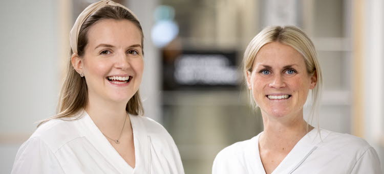Två glada anställda sjuksköterskor