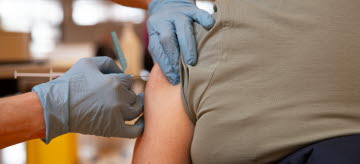 En person får en vaccinspruta i armen.
