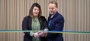 två personer klipper ett ceremoniellt band