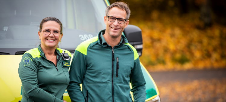 Två ambulanssjuksköterskor står framför en ambulans