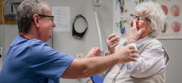 Läkare gör undersökning på äldre kvinna