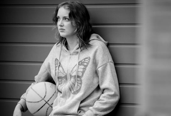 Bild på tonårsflicka med basketboll.