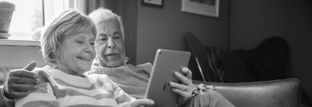Seniorer som tittar på en läsplatta. 