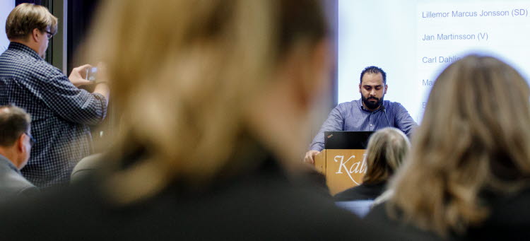 Mahmoud Al Mokdad (C) som pratar framför regionfullmäktige från talarstolen.