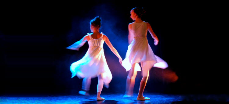 Bild på två flickor i klänning som dansar.