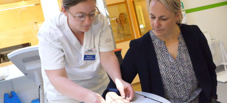 Röntgensjuksköterskan Noëlle lägger en patients hand i rätt position för röntgen.