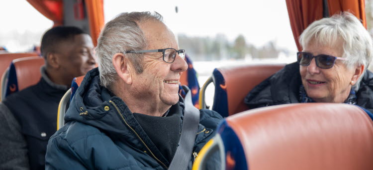 Två glada resenärer åker buss.