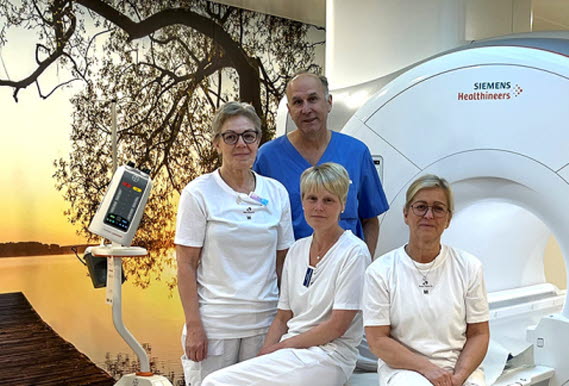 Bild på fyra medarbetare framför en av de nya MR-kamerorna. Från vänster:Ann-Christine Svensson undersköterska, Aleksandar Brzakovic MR-ansvarig överläkare, Helene Walder röntgensjuksköterska, Anette Kolm MR-ansvarig röntgensjuksköterska. 